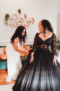 two women in black dresses standing next to each other