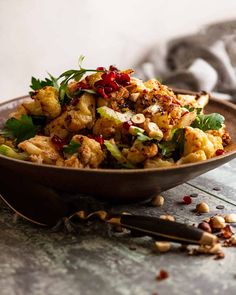 a brown bowl filled with food on top of a table