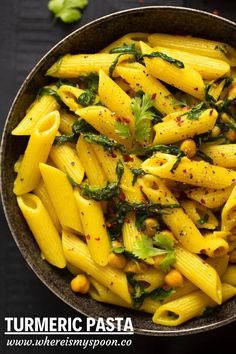 pasta with spinach and chickpeas in a bowl on a black table top