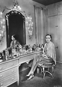 a woman sitting in front of a dressing table