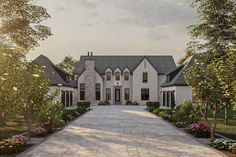 a large white house surrounded by trees and flowers