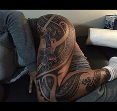 a man laying on top of a couch covered in tattoos