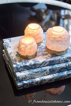 three lit candles sitting on top of blue and white napkins