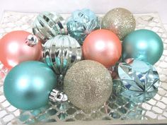 a glass bowl filled with christmas ornaments on top of a table