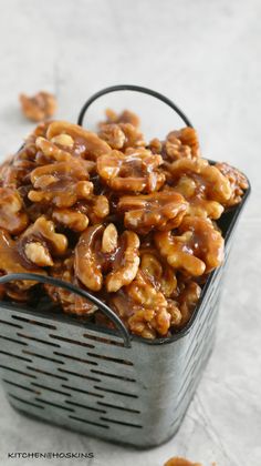 a metal basket filled with nuts on top of a table