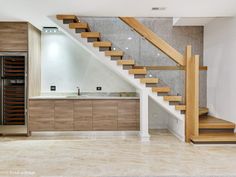 an empty kitchen with wooden stairs leading up to the upper floor and wine cellar below