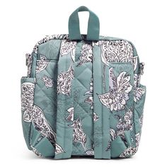 a blue backpack with white flowers and butterflies on the front, sitting against a white background