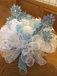 a blue and white centerpiece with candles on a wooden table in front of a door