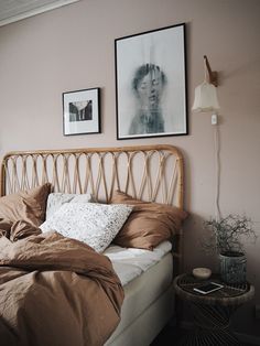 a bed with two pictures on the wall above it