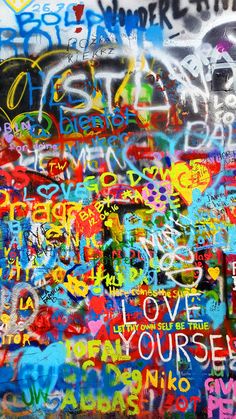 graffiti on the side of a wall with words and phrases written all over it in different colors