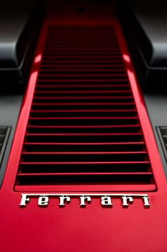 the front end of a red ferrari sports car with its emblem on it's side