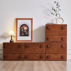 a wooden dresser sitting next to a lamp on top of a hard wood floored floor