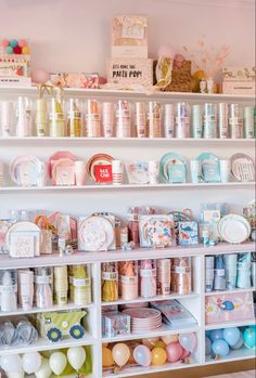 the shelves are filled with many different types of items and balloons on display in front of them