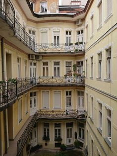 an apartment building with several balconies and balconyes on the second floor, looking down at the courtyard