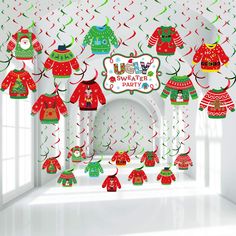 christmas sweaters hanging from the ceiling in front of a party banner and table cloth