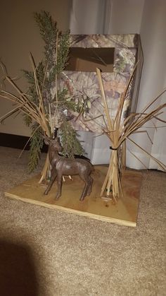 a deer figurine sitting next to a fake tree