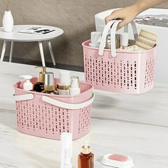 two pink baskets filled with personal care items on top of a white counter next to a bath tub