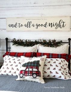 a bed topped with pillows and blankets next to a wooden sign that reads, and to all a good night