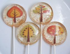 four lollipops with trees painted on them