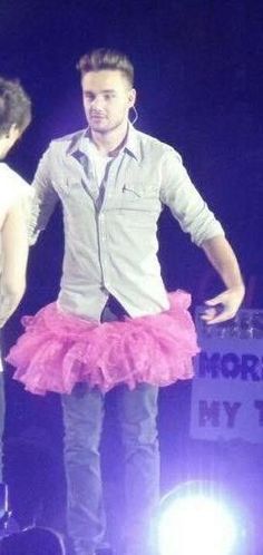 a man standing on top of a stage next to a woman in a pink tutu