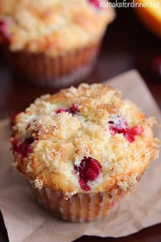 two cranberry muffins sitting on top of a piece of wax paper