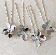 Enhance your special occasion hairstyle with these exquisite flower hair pins. Each pin features a stunning silver flower with a delicate crystal centre, meticulously hand-wired onto a silver hairpin. This set includes four beautiful hair pins, perfect for brides, bridesmaids, flower girls, or any special event. These flowers can be made with a pearl centre instead, please message to enquire. Also available in gold. Silver Flower Lapel Pin Gift, Silver Flower Hair Accessories, Formal Silver Flower-shaped Clip-on Earrings, Silver Flower Wedding Brooches, Silver Flower Hair Pins, Silver Hair Pin, Pearl Accessories, Special Occasion Hairstyles, Flower Hair Pin