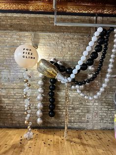 some balloons are hanging from the ceiling in front of a brick wall and wooden floor