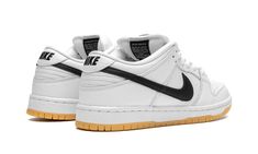 The Nike SB Dunk Low “White/Gum” is a timeless colorway of the retro skate shoe.  Dubbed simply “White/Gum” by Nike SB, this Dunk Low features a versatile white-and-black color block on its design.  Specifically, the shoe is constructed with a white leather upper.  A black leather Swoosh appears on either side of the shoe and black “Nike” branding is embroidered on the heel.  Classic “Nike SB Dunk” detailing is found on the tongue tag.  A white midsole and gum rubber outsole complete the look. Nike Sneakers For Skateboarding With Gum Sole, Nike Sneakers With Gum Sole For Streetwear, Nike Urban Sneakers With Gum Sole, White Sporty Sneakers With Gum Sole, White Sporty Custom Sneakers With Gum Sole, White Rubber Sole Skate Shoes For Streetwear, Nike White Urban Sneakers, Nike White Sneakers For Streetwear, White Nike Urban Sneakers