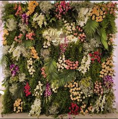 the floral wall is decorated with flowers and greenery