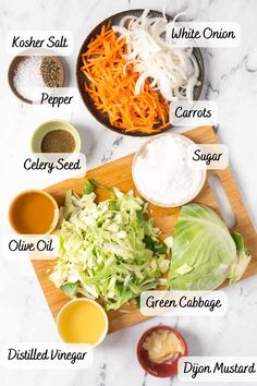 ingredients to make cabbage salad laid out on a cutting board, including carrots, celery, green cabbage, mustard, and seasonings