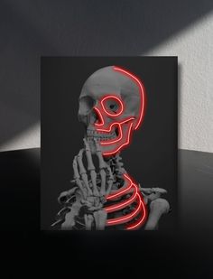 a lit up skeleton sitting on top of a table next to a black and white wall