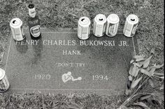 the headstone of henry charles bukowski jr is surrounded by empty bottles