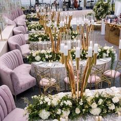 tables and chairs are set up with white flowers, candles and greenery on them