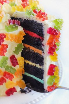 a cake with gummy bears on it and a slice taken out