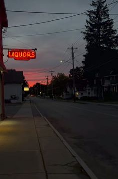 a sign that is on the side of a building at night with lights in front of it