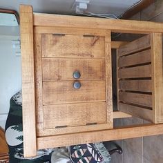 a wooden cabinet sitting on top of a tiled floor