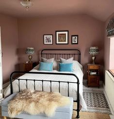 a bed room with a neatly made bed and pictures on the wall