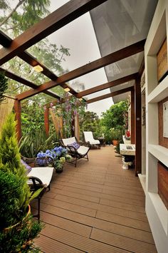 an outdoor covered patio with lounge chairs and potted plants