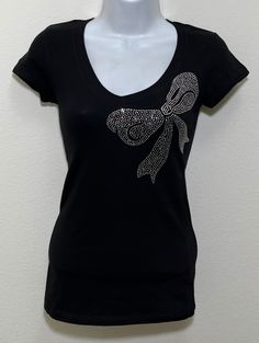 Fabric comprised of 95% cotton and 5% spandex.  Handmade rhinestone t-shirts made in the United States with quality rhinestones. Machine washable. T-shirt style is a fitted V-neck cap sleeve. Size Range:         XXS = 2         XS = 4         S = 6         M = 8         L = 10         XL = 12 Fitted V-neck Top With Rhinestones, Cotton T-shirt With Rhinestones And Short Sleeves, Cotton Short Sleeve T-shirt With Rhinestones, Cotton T-shirt With Rhinestones Short Sleeve, Embellished Fitted Cotton T-shirt, Fitted Cotton Embellished T-shirt, Graphic Tee T-shirt With Rhinestones, Short Sleeve, Black Cotton T-shirt With Rhinestones, Rhinestone Cotton Tops With Short Sleeves