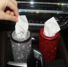 two tissue dispensers sitting on top of a car dashboard next to each other