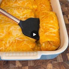 a casserole dish with cheese and a spatula in it