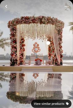 an outdoor ceremony setup with flowers and chandelier on the water's edge