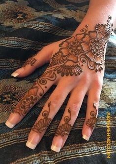 a woman's hand with henna tattoos on it