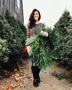 a woman is holding christmas trees in her hands