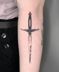 a tattoo on the arm of a woman with a knife in it's center