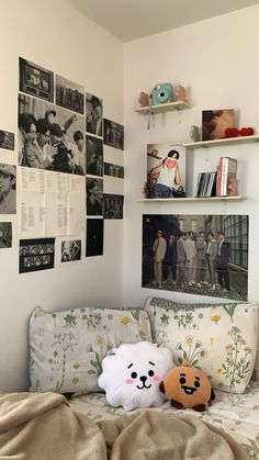 two stuffed animals sitting on top of a bed in a room filled with pictures and books