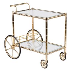 a golden bar cart with wheels and a glass table top on it's side