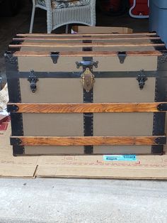 an old trunk sitting on top of a cardboard box