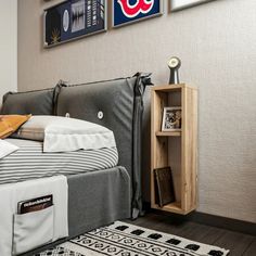 a bedroom with a bed, nightstand and pictures on the wall