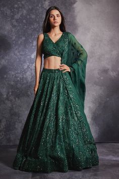 Topaz green flared lehenga with all over floral pattern, tonal sequin, glass beads and stone embroidery. Paired with embroidered blouse with overlap panel and dupatta.
Components: 3
Pattern: Embroidered
Type Of Work: Sequin, Glass Beads and Stone Work
Neckline: Sweetheart Neck
Sleeve Type: Sleeveless
Fabric: Silk Organza 
Color: Green
Other Details: 
Cut work dupatta hem
Inverted V blouse hem
Wrap blouse
Closure: Blouse: Back tie-up
Note: The outfit worn by the other model on the right is not fo Green Dresses With Traditional Drape And Sequins, Green Dresses With Sequins In Traditional Drape, Fitted Green Anarkali Set For Party, Festive Green Anarkali Set With Sequins, Green Fitted Party Wear Choli, Green Sequined Anarkali Set For Designer Wear, Green Sequined Sets For Navratri, Festive Green Sequined Anarkali Set, Green Sequined Sets For Reception